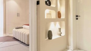 A modern hotel room with a bed, a wardrobe, and a wall with decorative cutouts. - Opulence Reality Stays (Lagos)