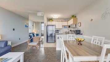 Een compacte woonruimte met een kitchenette, een eethoek en een zithoek met uitzicht.