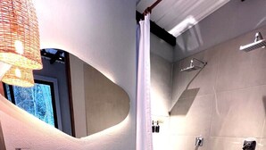 Un baño moderno con inodoro, lavamanos y ducha.