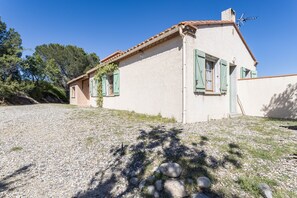 A single-story house with a tiled roof, green shutters, and a gravel driveway. - Holiday Home “Alba” with Mountain View, Private Pool and Air Conditioning (Latour-de-France)