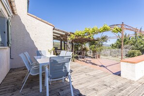 A patio with a table and chairs, a pergola with vines, and a view of the surrounding landscape. - Holiday Home “Alba” with Mountain View, Private Pool and Air Conditioning (Latour-de-France)