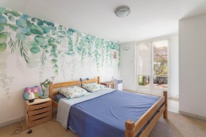 A bedroom with a bed, wooden nightstands, a wall-mounted lamp, and a window with blinds. - Holiday Home “Alba” with Mountain View, Private Pool and Air Conditioning (Latour-de-France)
