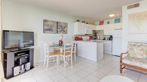 Ein kompakter Wohnbereich mit Fernseher, Essbereich, Küche und einer Couch.
