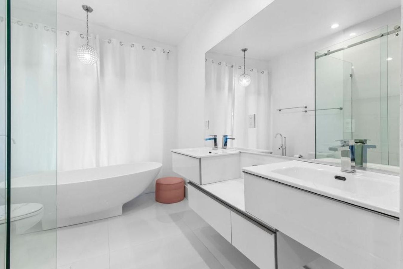 A modern bathroom with a bathtub, a shower, and a large mirror.