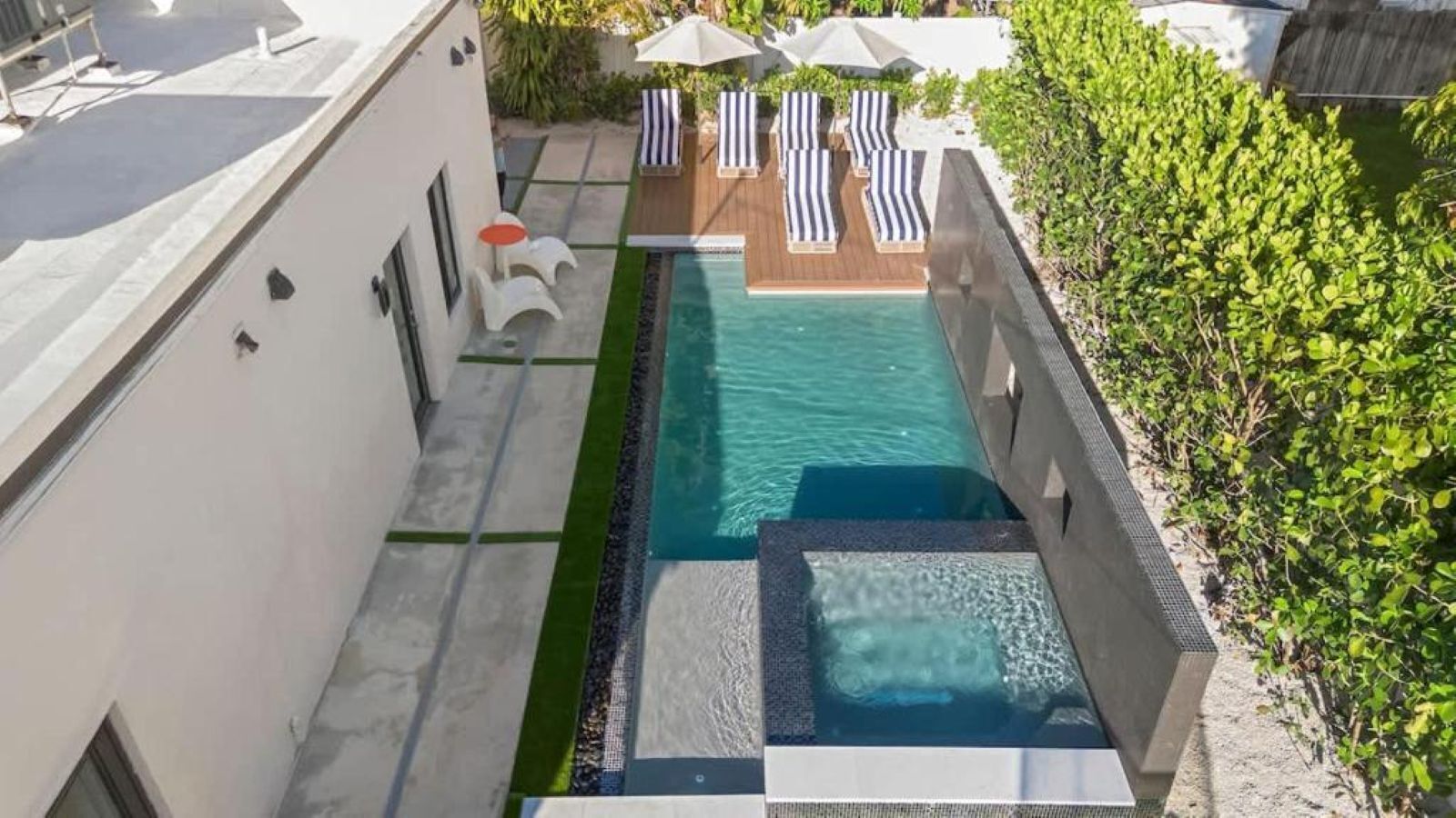 Piscina en la azotea con sillones de descanso y una pequeña mesa.
