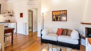 Una sala de estar con un sofá, una mesa de centro, una chimenea y un cuadro en la pared.