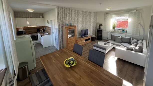 A compact living space with a kitchen, dining area, and seating area. - Vacation home Alte Schule (Dornumersiel)
