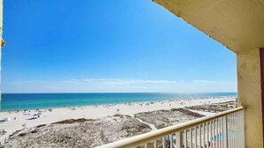Ein Balkon mit Blick auf Strand und Meer.