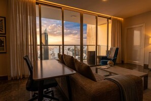 Una sala de estar moderna con un ventanal grande, una mesa de comedor, un sofá y una silla.