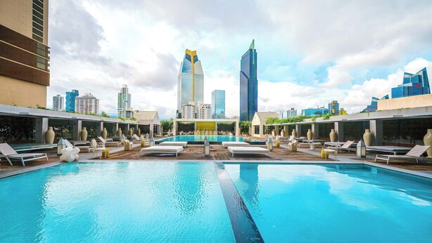A rooftop pool with lounge chairs and a city skyline in the background. - 31J Apto en Yoo, Lujoso con Vista al Mar de 2 rec (Panamá)