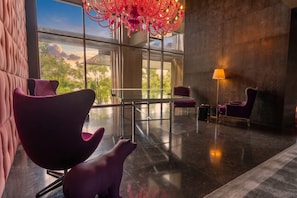 A modern lobby with a glass partition, a chandelier, and seating areas. - Apto 33H en YOO, vista a la ciudad con 1 recamara (Panamá)