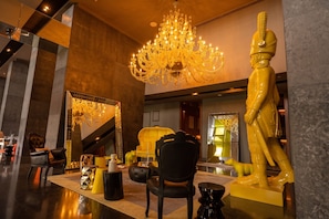 A luxurious lobby with a grand chandelier, a large mirror, and a statue. - Apto 33H en YOO, vista a la ciudad con 1 recamara (Panamá)