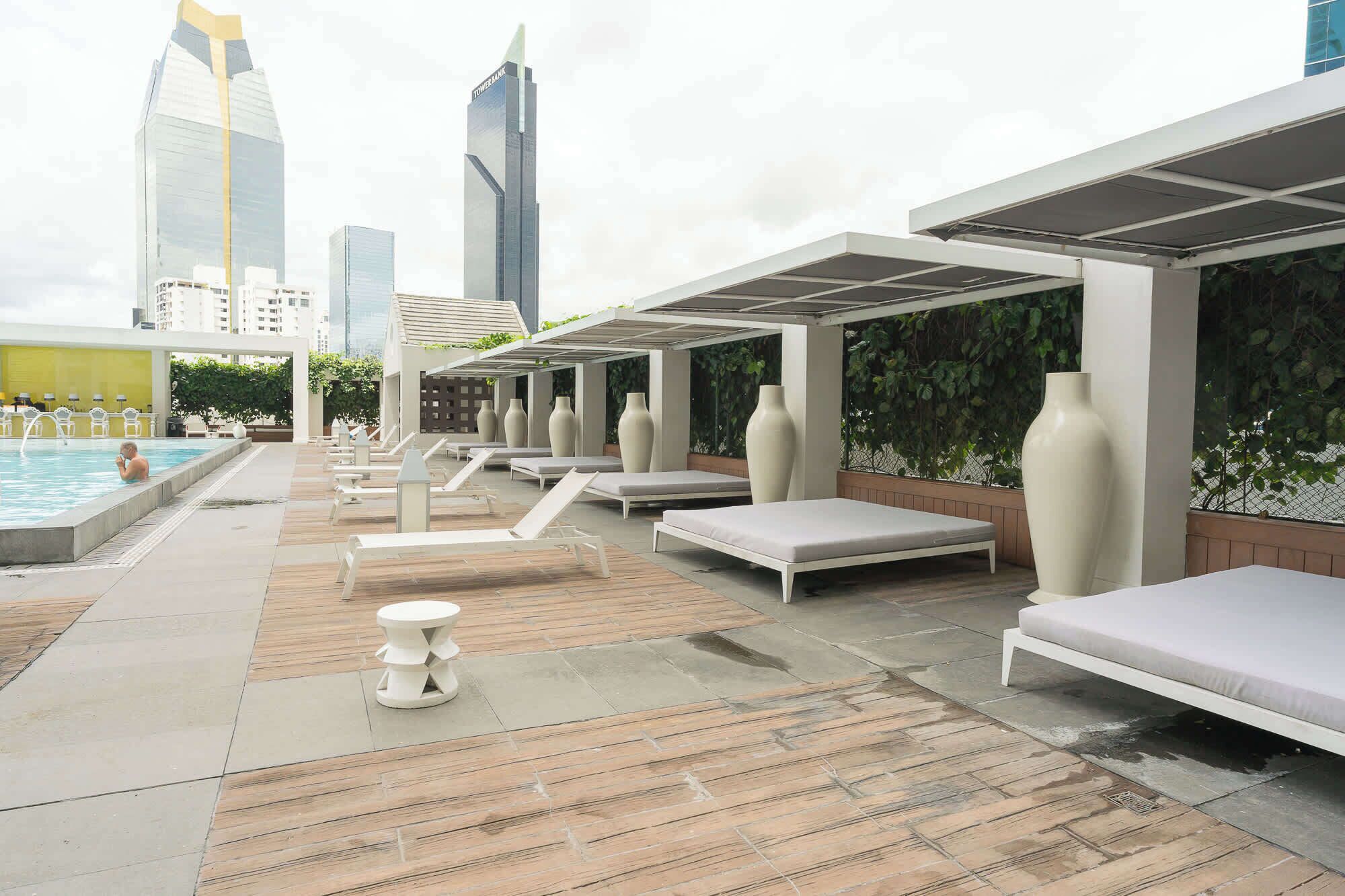 A rooftop pool area with lounge chairs and a small pool.