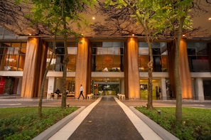 A modern building with large glass windows, a central entrance, and a pathway leading to the entrance. - Apto 33H en YOO, vista a la ciudad con 1 recamara (Panamá)