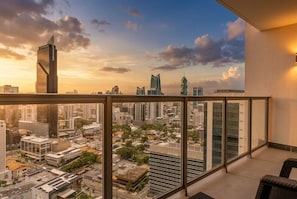 A high-rise building with a view of a cityscape, including modern skyscrapers and a sunset sky. - Apto 33H en YOO, vista a la ciudad con 1 recamara (Panamá)
