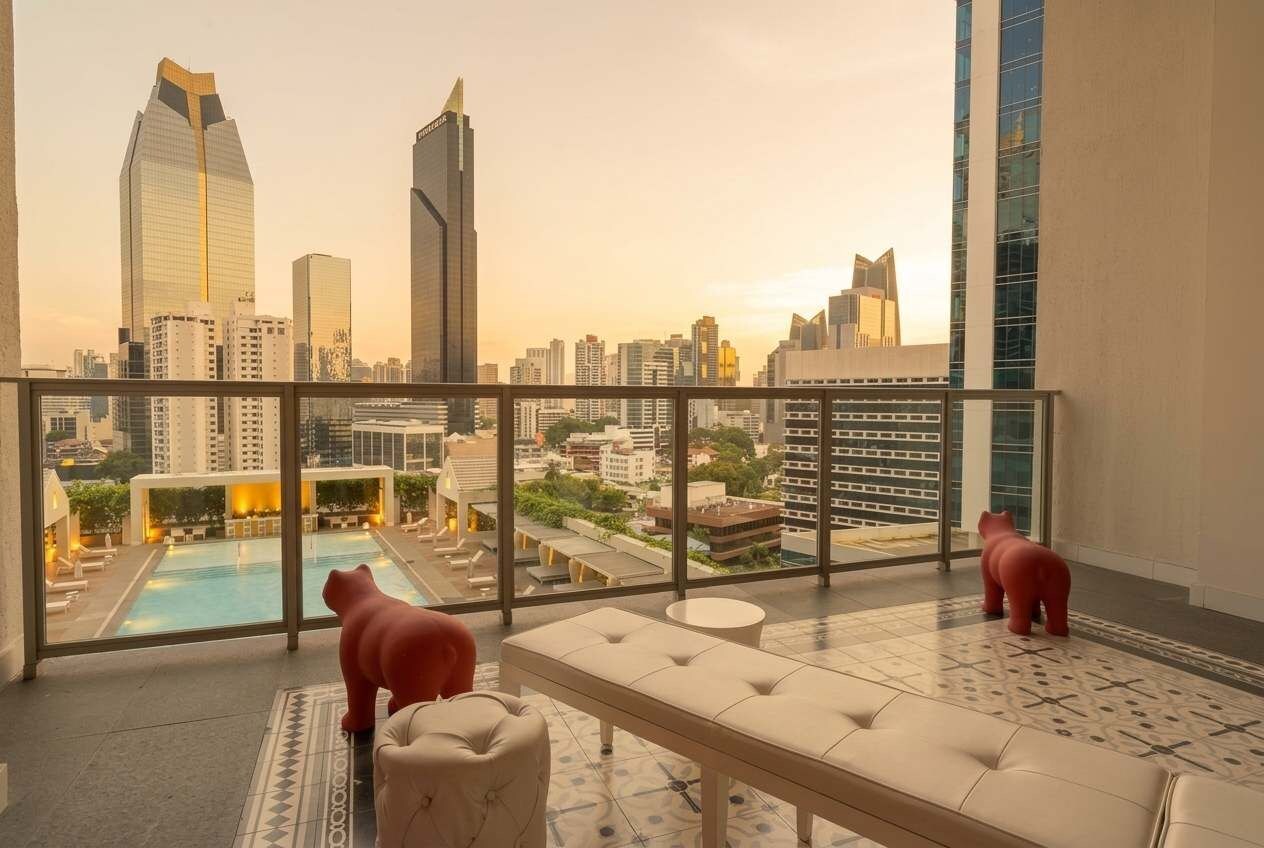 A rooftop terrace with a pool, seating area, and a view of the city skyline.
