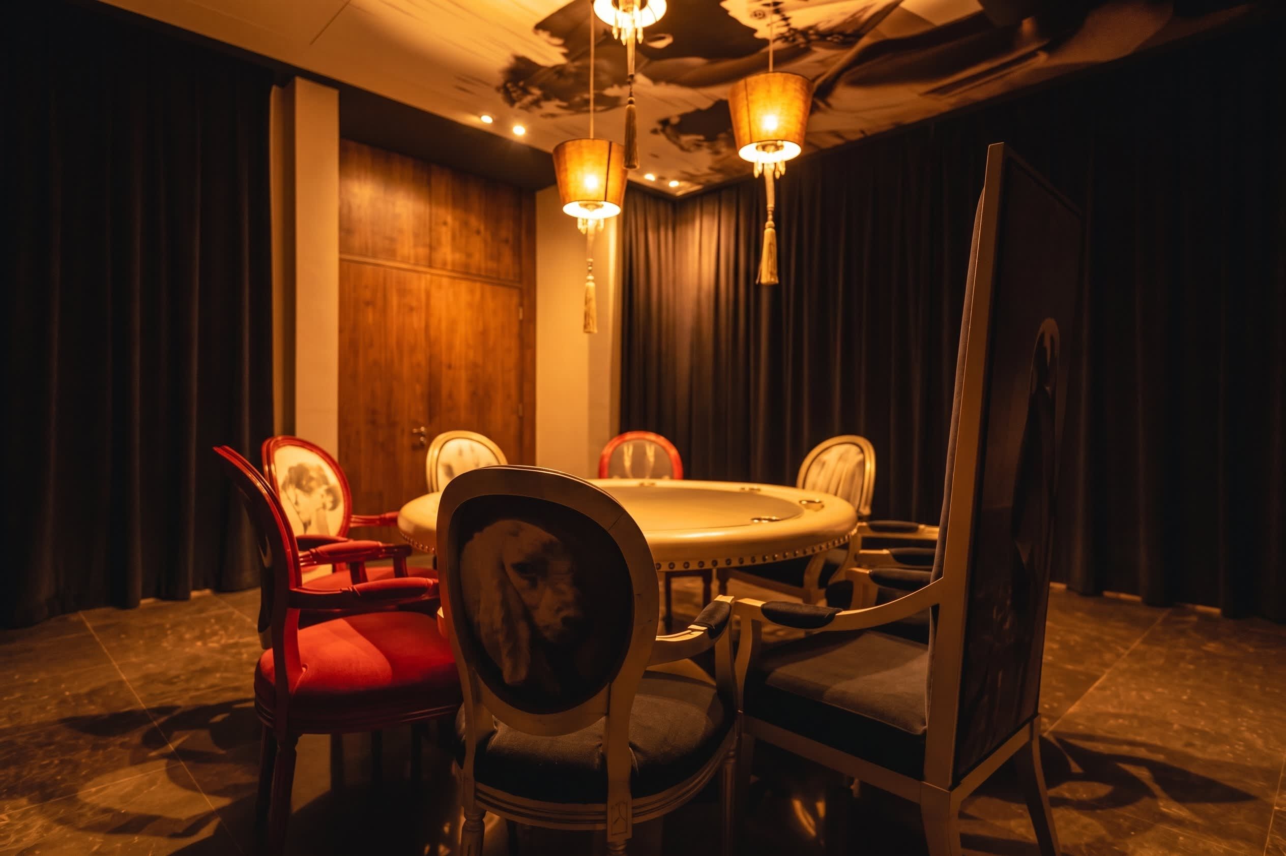 A conference room with a round table, chairs, and a chandelier.