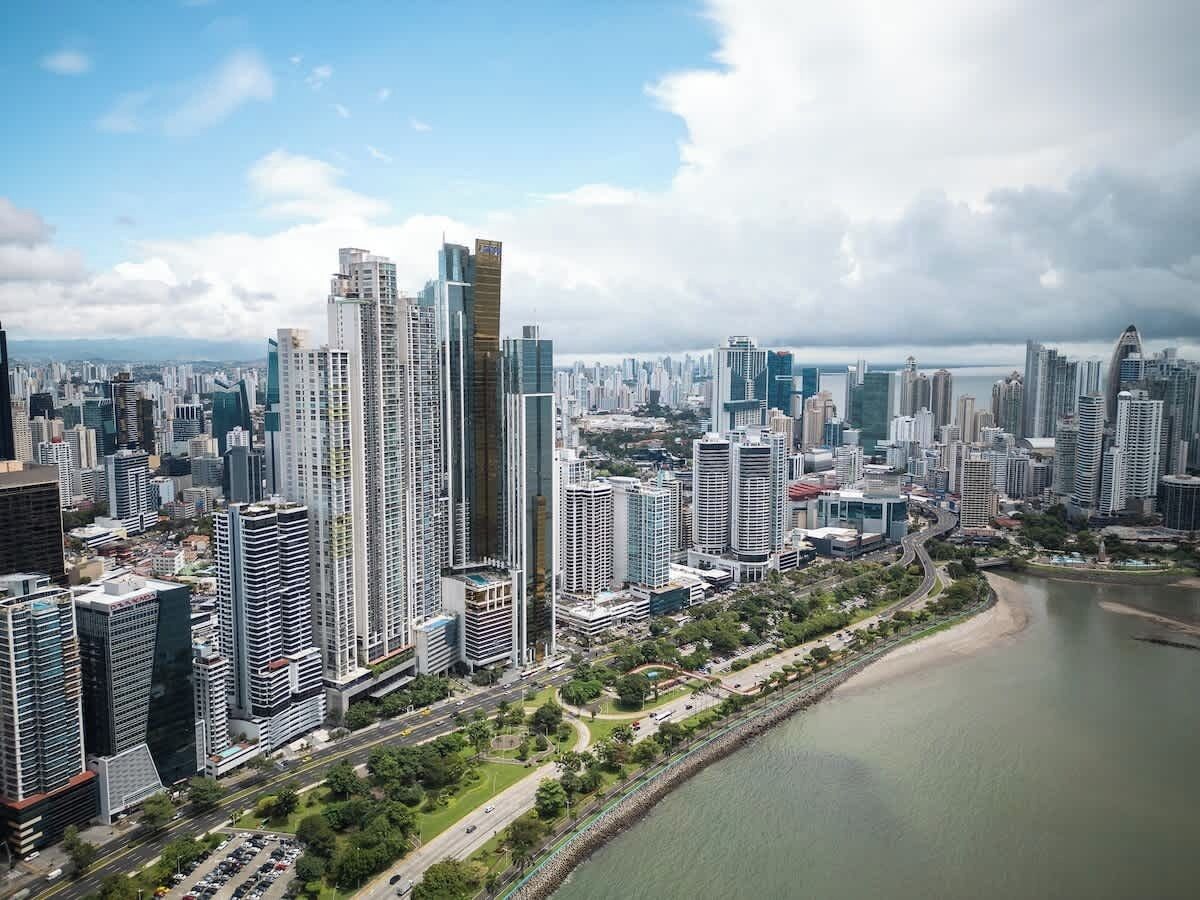 A cityscape with high-rise buildings, a river, and a clear sky.