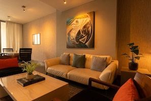 Ein modernes Wohnzimmer mit einer Couch, einem Couchtisch und einem Bild an der Wand.
