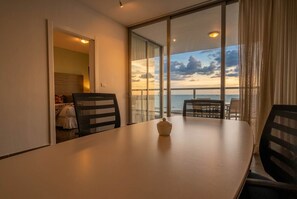 A hotel room with a balcony, a dining table, and a view of the sea. - 25J Lujoso Apto en YOO, vista al mar con 2 recámaras (Panamá)