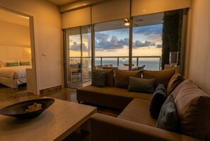 A modern hotel room with a large balcony, a sofa, a coffee table, and a bed. - 22J apartamento full equipado vista al mar y 2 hab (Panamá)