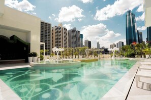 Una piscina dal design moderno, circondata da lettini e piante in vaso.