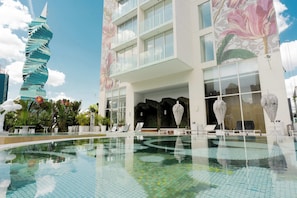 A modern hotel with a unique spiral tower, a large indoor pool, and a floral mural on the facade. - 24G Apto en Wanders & Yoo Marbella con 3 recamaras (Panama City)