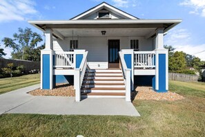 A two-story house with a front porch, a staircase, and a small front yard. - The Barker Bungalow - Charming 3 bedroom in Historic Town near shops and dining (Saint Charles)