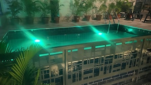 Un espace piscine agrémenté de plantes en pot et doté d’une rambarde en verre.