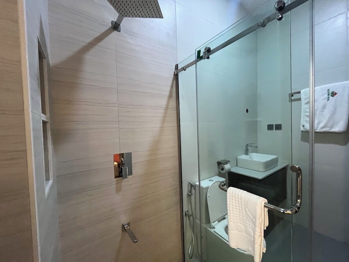 Une salle de bain moderne avec une douche à parois de verre, un porte-rouleau de papier toilette visible et un porte-serviettes.