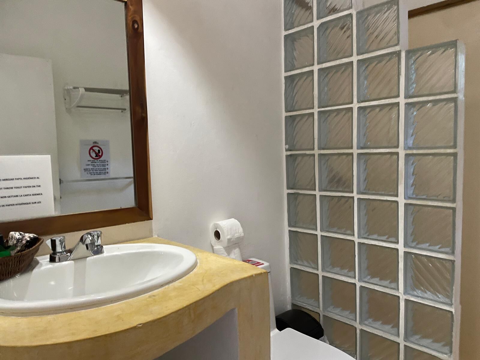 A bathroom with a sink, mirror, and a glass shower enclosure.