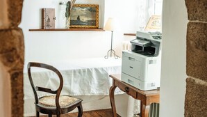 A room with a wooden desk, a chair, a printer, and a framed picture on the wall. - Charming manor house in Brittany (Binic-Étables-sur-Mer)