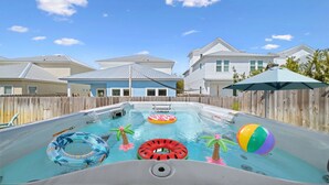 A swimming pool with inflatable toys, a hot tub, and a wooden fence. - Pet friendly, walk to the beach, Master Swim Spa & Firepit -Villas of Frangista (Miramar Beach)