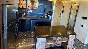 Una cocina moderna con suelo de mármol, electrodomésticos de acero inoxidable y una isla central.