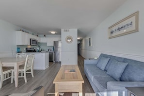 Eine moderne Wohnung mit Küche, Essbereich und Wohnzimmer.