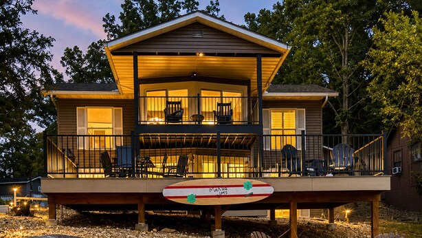 A house with a deck, outdoor seating, and a pond. - Makua Jim’s - Quiet Cove Retreat with Swim Dock, 3 Decks, boat slip, & game room (Sunrise Beach)