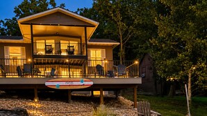 A modern house with a deck, a pool, and a wooden boat. - Makua Jim’s - Quiet Cove Retreat with Swim Dock, 3 Decks, boat slip, & game room (Sunrise Beach)