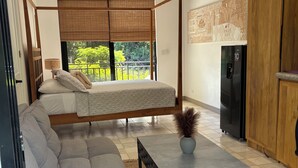 Ein modernes Schlafzimmer mit Himmelbett, einer Couch, einem Couchtisch und einem Kühlschrank.
