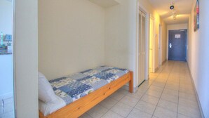 Un estrecho pasillo con una cama individual en una habitación.