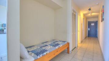 A narrow hallway with a single bed in a room.