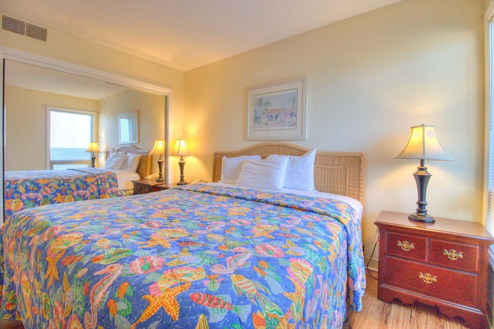 A hotel room with two beds, a dresser, a mirror, and a painting on the wall.