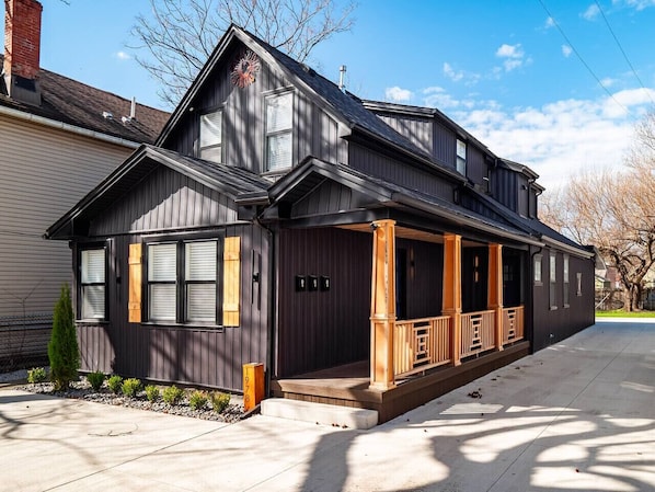 A two-story house with a front porch, a chimney, and a mailbox.