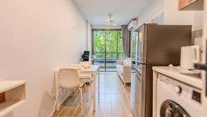 A compact kitchen with a dining area, a washing machine, and a ceiling fan. - ZcapeX2 (Choeng Thale)