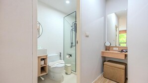 A modern bathroom with a toilet, sink, mirror, and shower area. - ZcapeX2 (Choeng Thale)