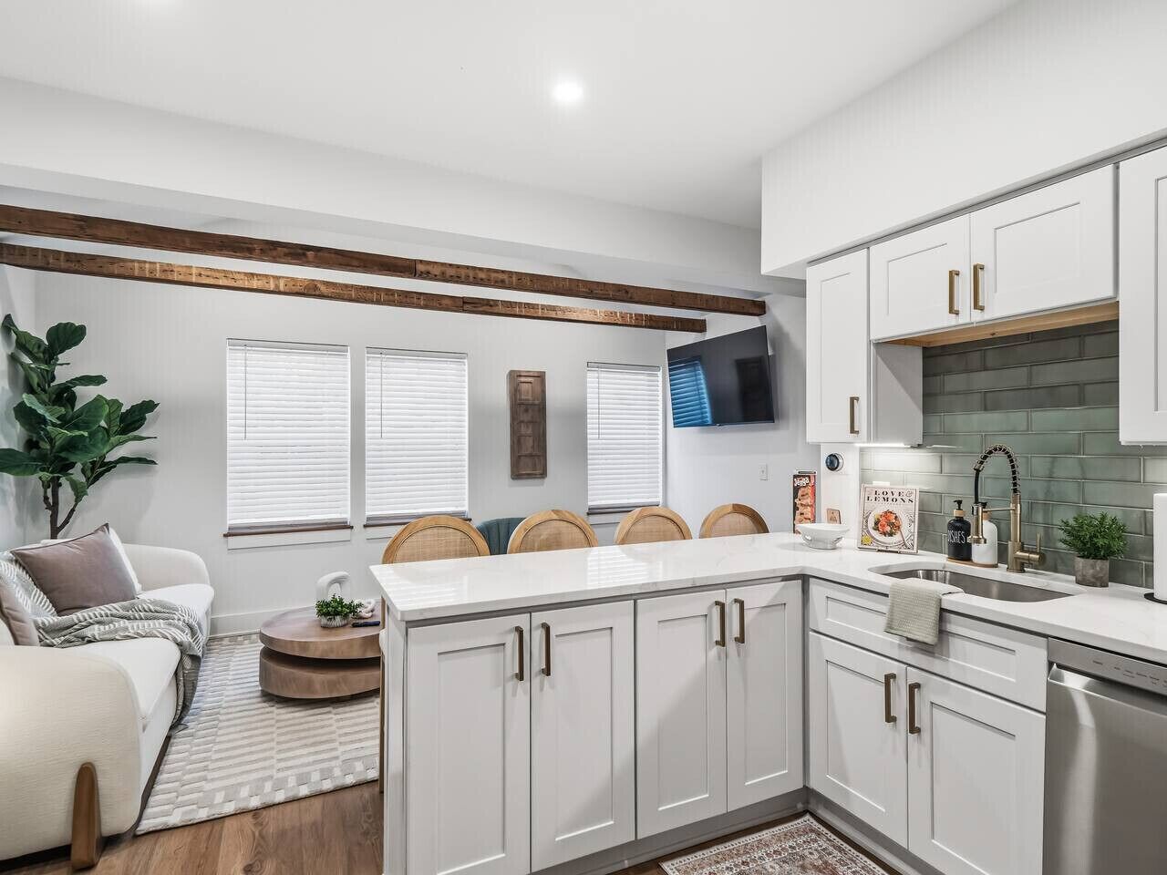 A modern kitchen with white cabinets, a built-in oven, and a large island with seating.