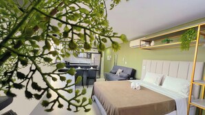A modern hotel room with a bed, a desk, and a kitchenette. - Vol 29 - Miramar Hospedagens (João Pessoa)