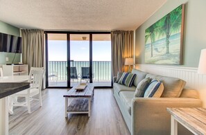 Ein modernes Wohnzimmer mit einer Couch, einem Holztisch und einem Essbereich mit Stühlen.