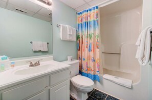 Een badkamer met een wastafel, toilet, douche en een spiegel.