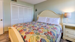 Un dormitorio con cama, mesita de noche, lámpara, armario y calentador de pared.