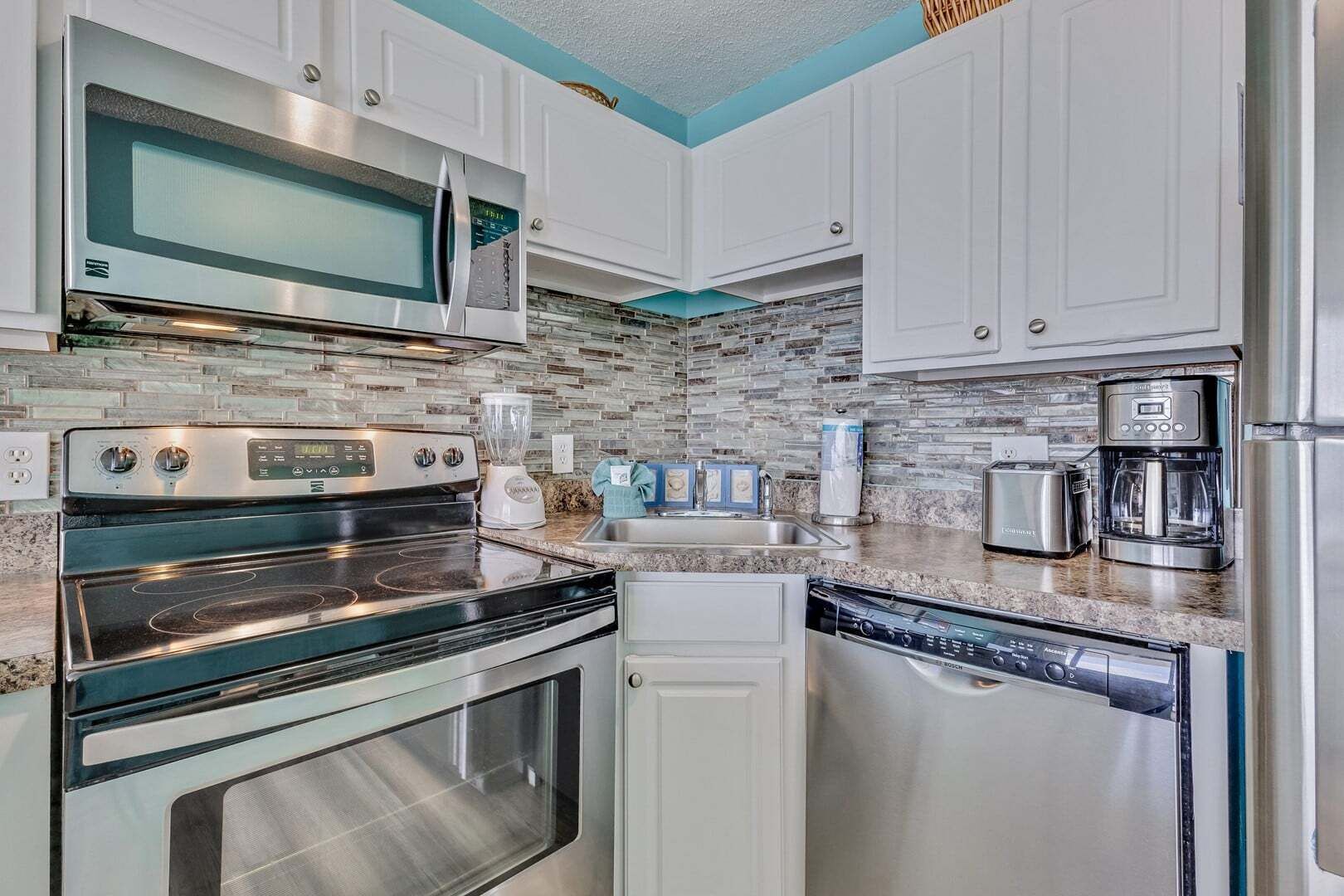 Una cocina moderna con electrodomésticos de acero inoxidable, lavavajillas y horno empotrado.